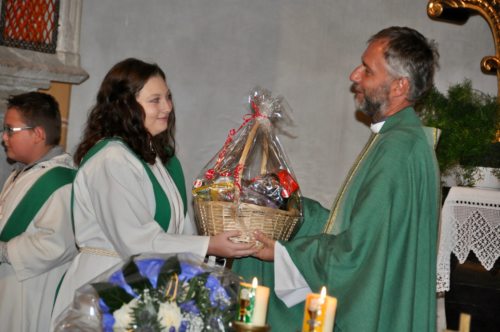 Jullia Amschl überreicht Herrn Pfarrprovisor Tomecki einen gut gefüllten Geschenkskorb (© Foto: Mag. Dr. Christiana Potocnik)