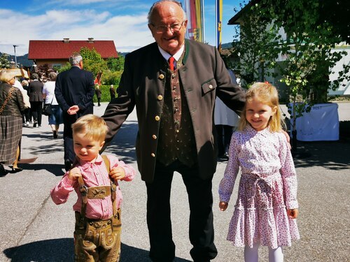 Der stolze Opa mit seinen beiden jüngsten Enkeln • Ponosni dedej s svojo najmlajšo vnukinjo in z vnukom (Foto: Pfarrarchiv Neuhaus- Suha)